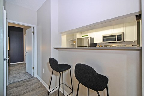 a kitchen with two stools in front of a counter top