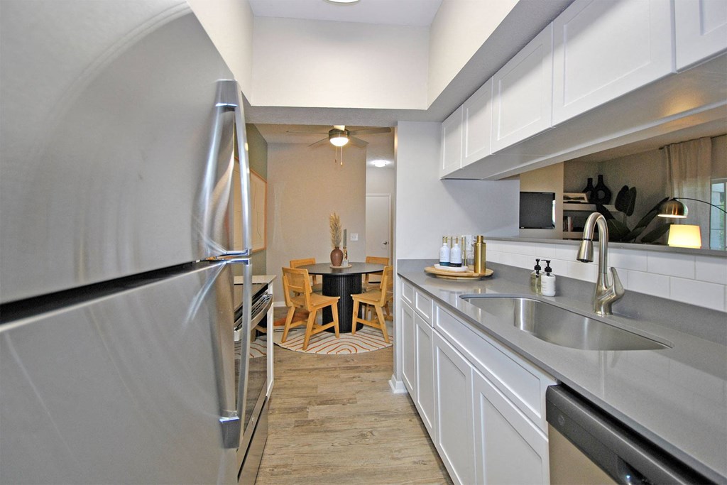 a kitchen with white cabinets and a stainless steel refrigerator