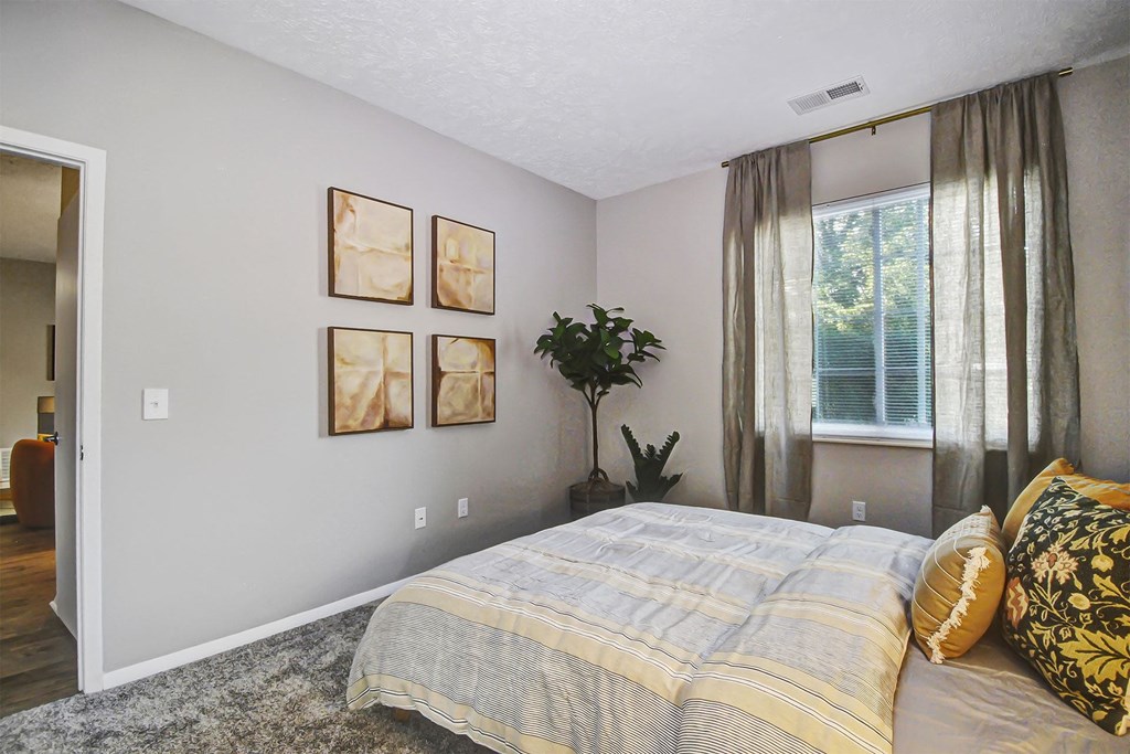 a bedroom with a bed and some pictures on the wall