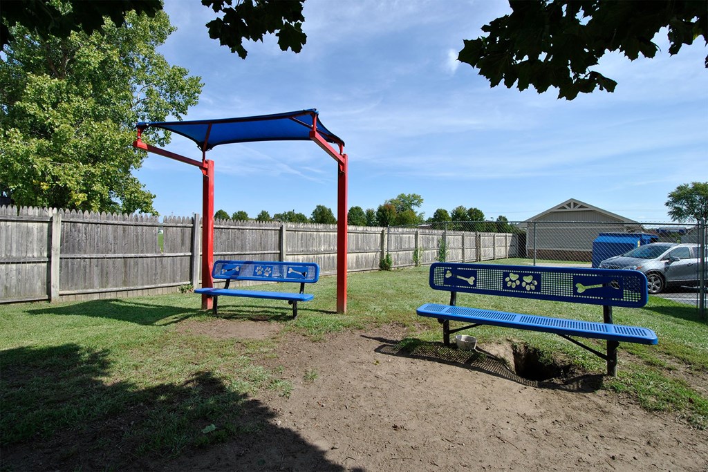 a playground with two blue benches and a swing set