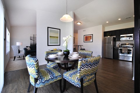 A modern dining room with a round table and matching chairs.
