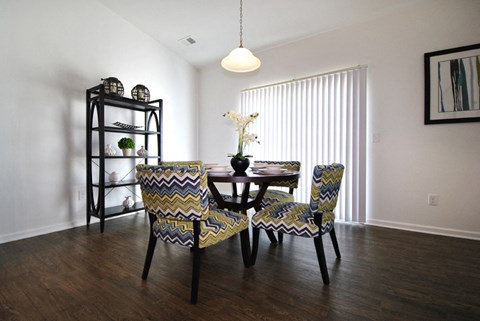 A dining room with a table and chairs.