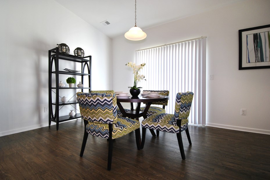 A dining room with a table and chairs.