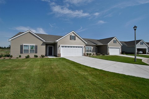 A house with a grey roof and a white garage door.