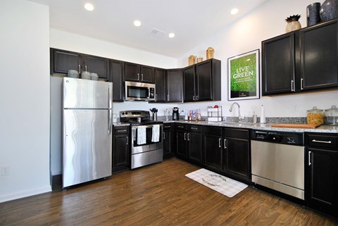 A kitchen with black cabinets and stainless steel appliances.