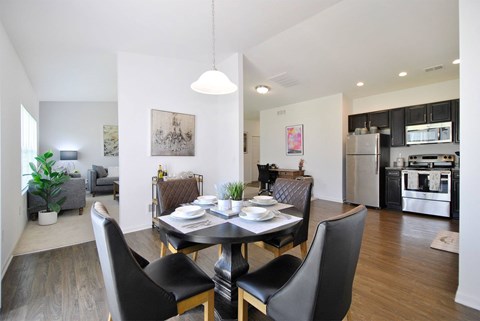 A modern dining room with a black table and chairs.