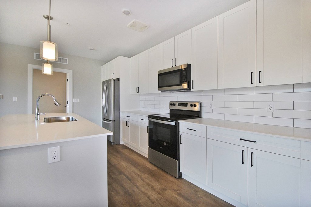 a kitchen with white cabinets and a sink and a refrigerator