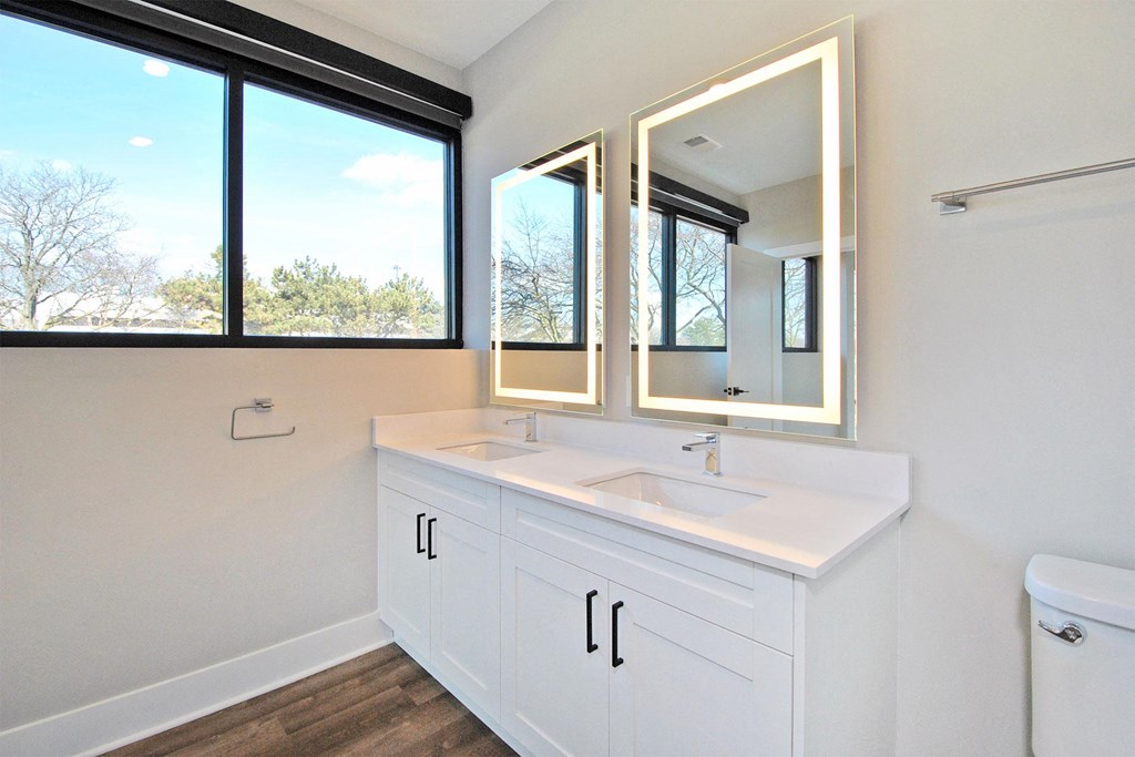 a bathroom with a sink and three mirrors