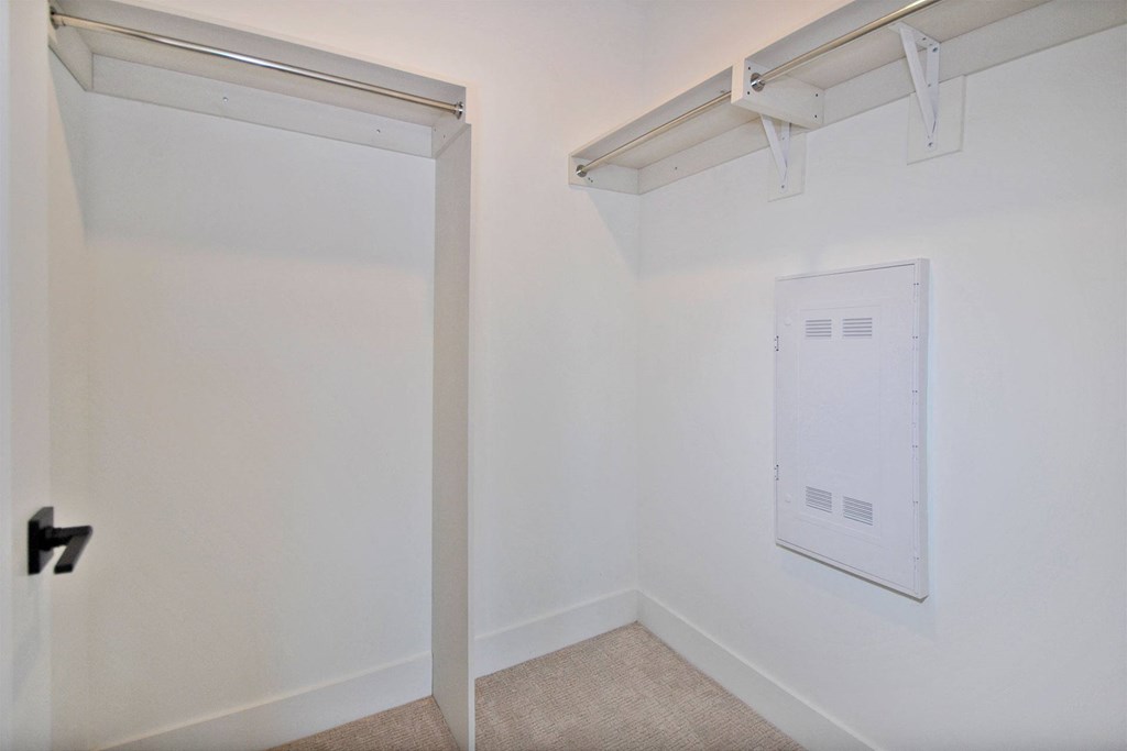 a white room with a white wall and a door to a white closet