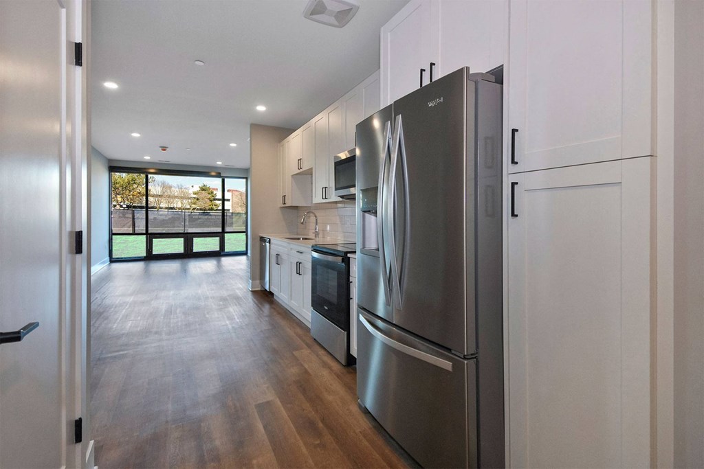 a renovated kitchen with stainless steel appliances and white cabinets