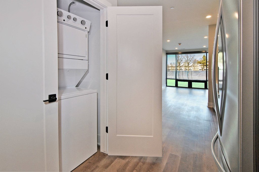 a kitchen with a refrigerator and a washer and dryer in a house
