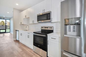 a kitchen with white cabinets and a stove and a microwave