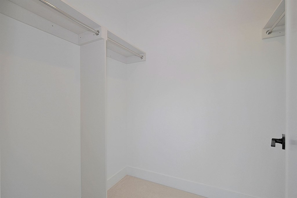an empty room with white walls and a black door
