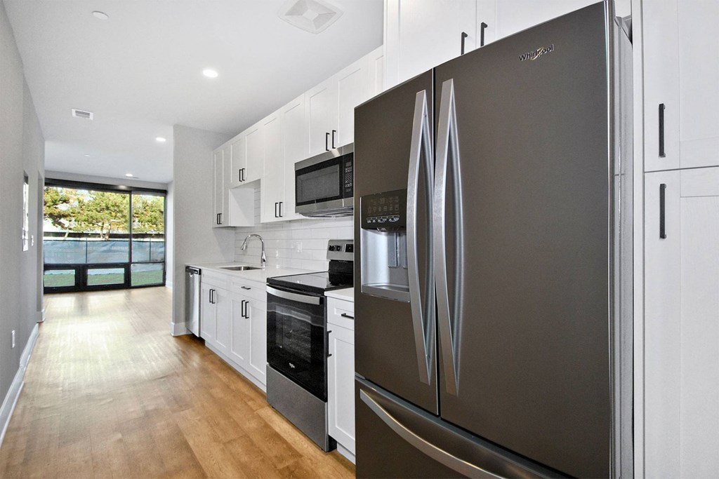 a kitchen with stainless steel appliances and white modern cabinets