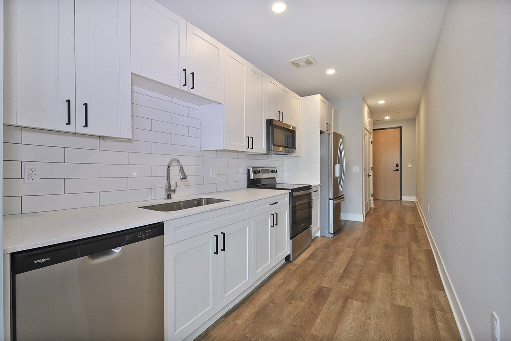 a renovated kitchen with white cabinets and stainless steel appliances