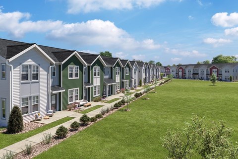 A row of houses with green lawns in front.