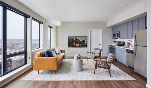 A living room with a yellow couch and a painting on the wall.