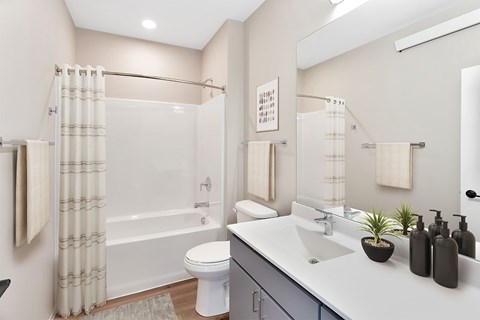A bathroom with a white toilet, a white sink, and a white bathtub with a shower curtain.