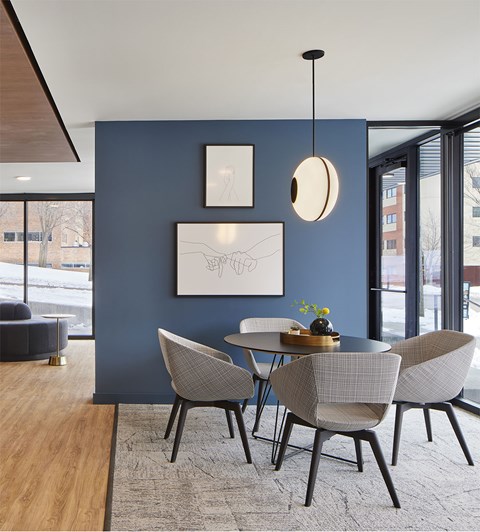 A modern dining room with a round table and chairs.