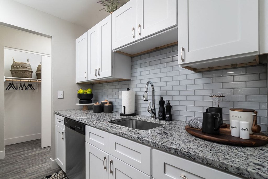 a kitchen with white cabinets and a sink
