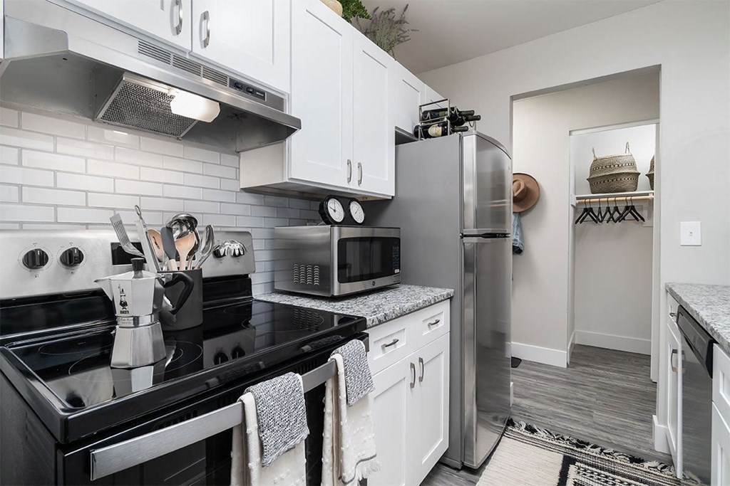 a kitchen with stainless steel appliances and white cabinets