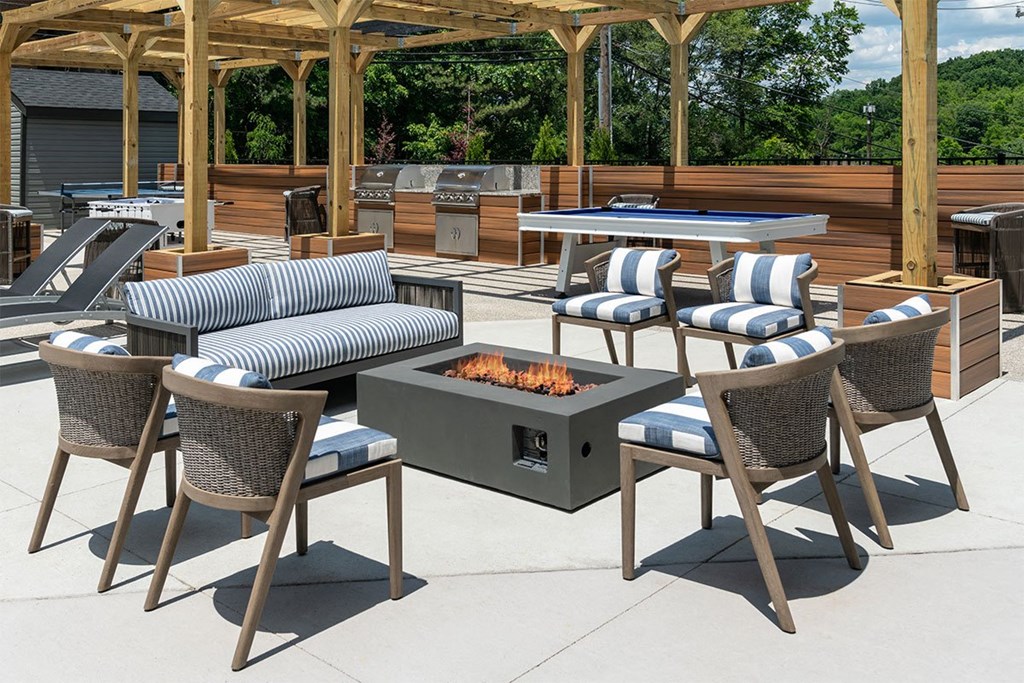 a patio with a fire pit and chairs and tables