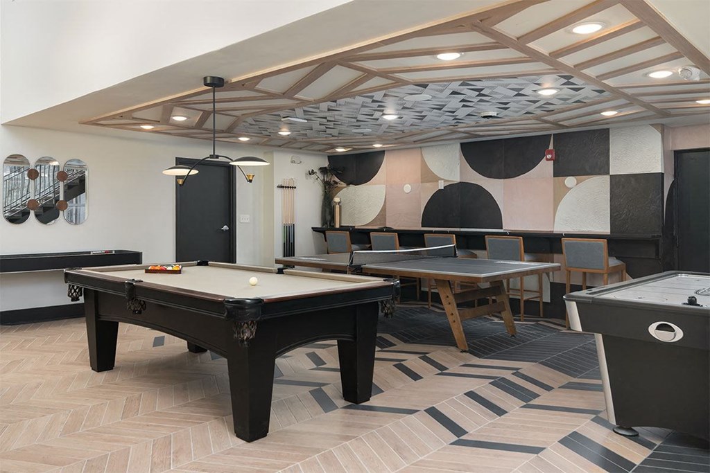 a game room with two pool tables and a ping pong table