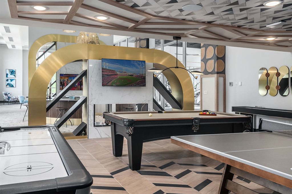 a game room with two pool tables and a television