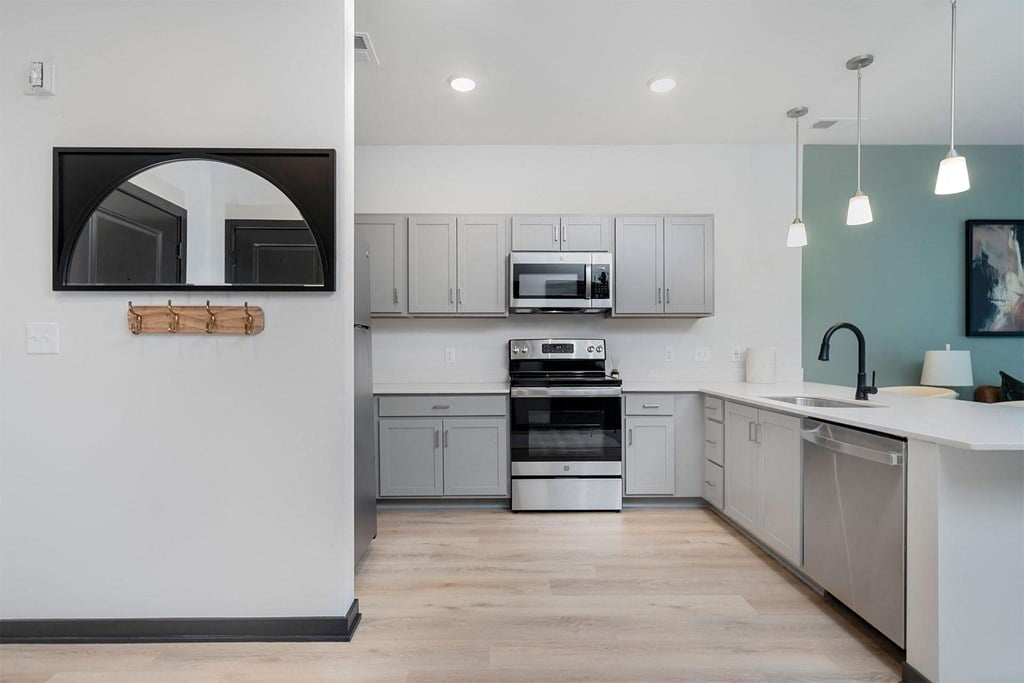 a kitchen with white cabinets and stainless steel appliances