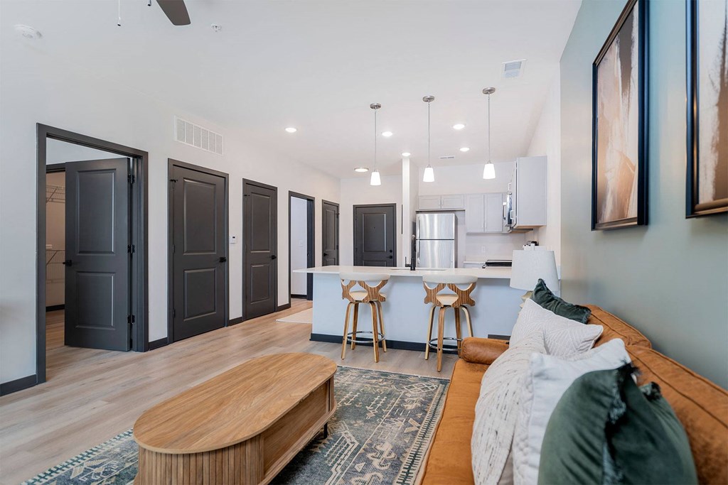 living room with sofa and coffee table and the kitchen in the background