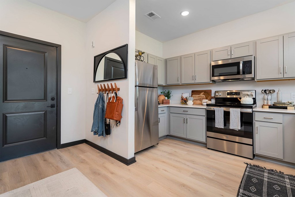 A kitchen with a refrigerator, oven, and microwave.