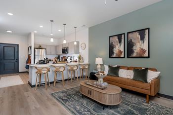 A modern kitchen with a bar and a couch in the living room.