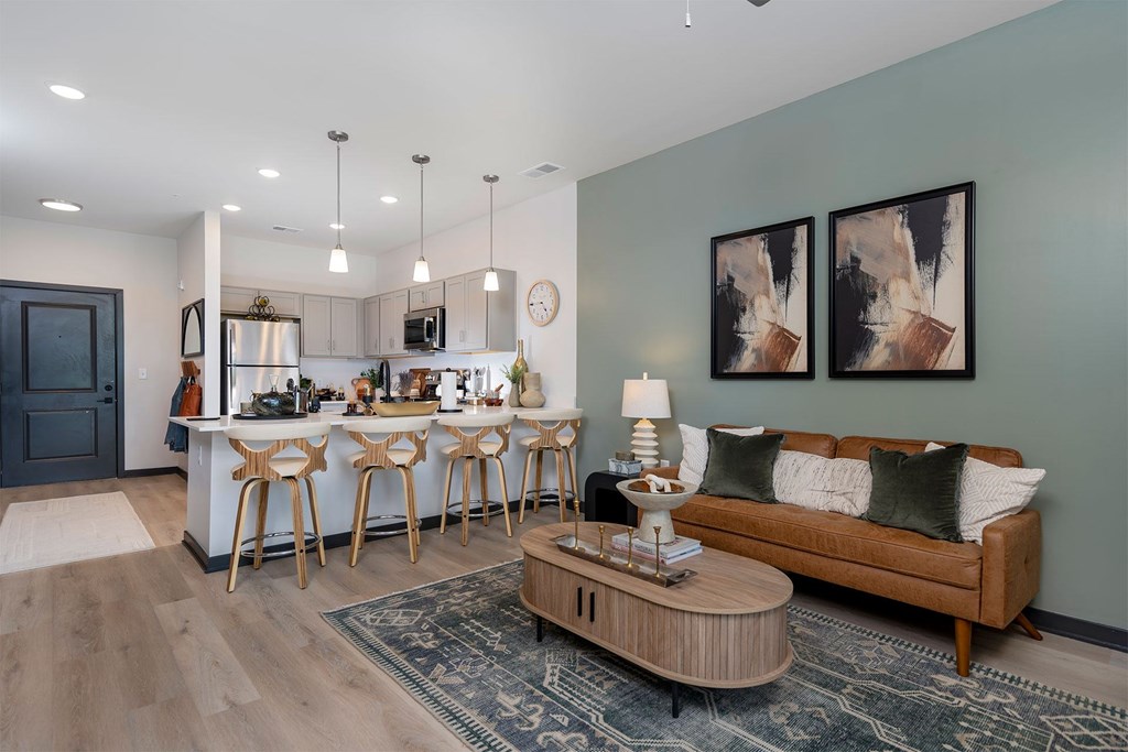 A modern kitchen with a bar and a couch in the living room.