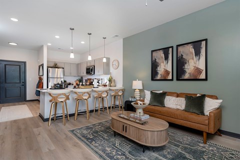 A modern kitchen with a bar and a couch in the living room.