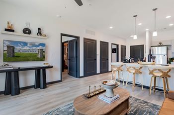 A modern living room with a wooden coffee table and a painting of a river ridge on the wall.