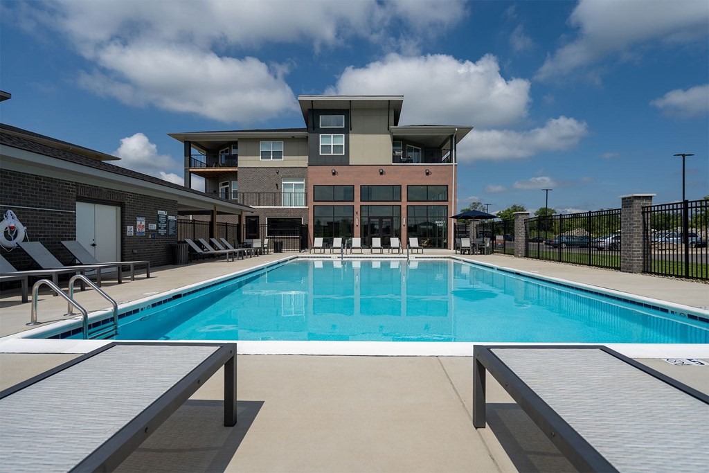 A large swimming pool in front of a multi-story building.
