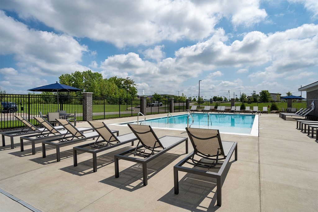 A poolside area with chairs and a pool.