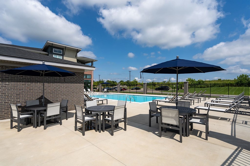 A poolside area with chairs and umbrellas.