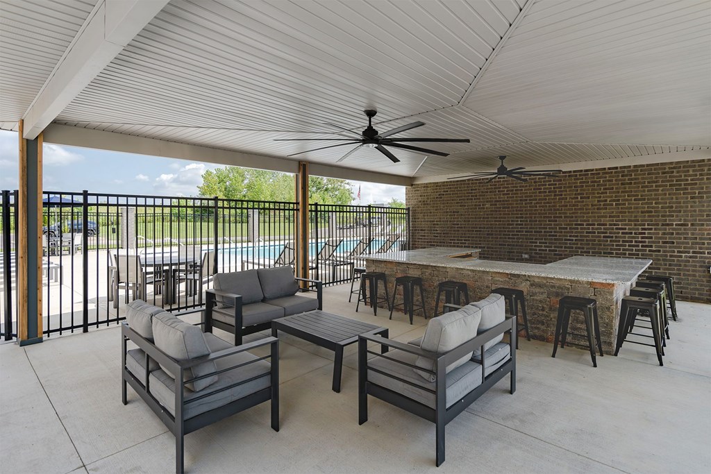 A patio with a table, chairs, and a ceiling fan.