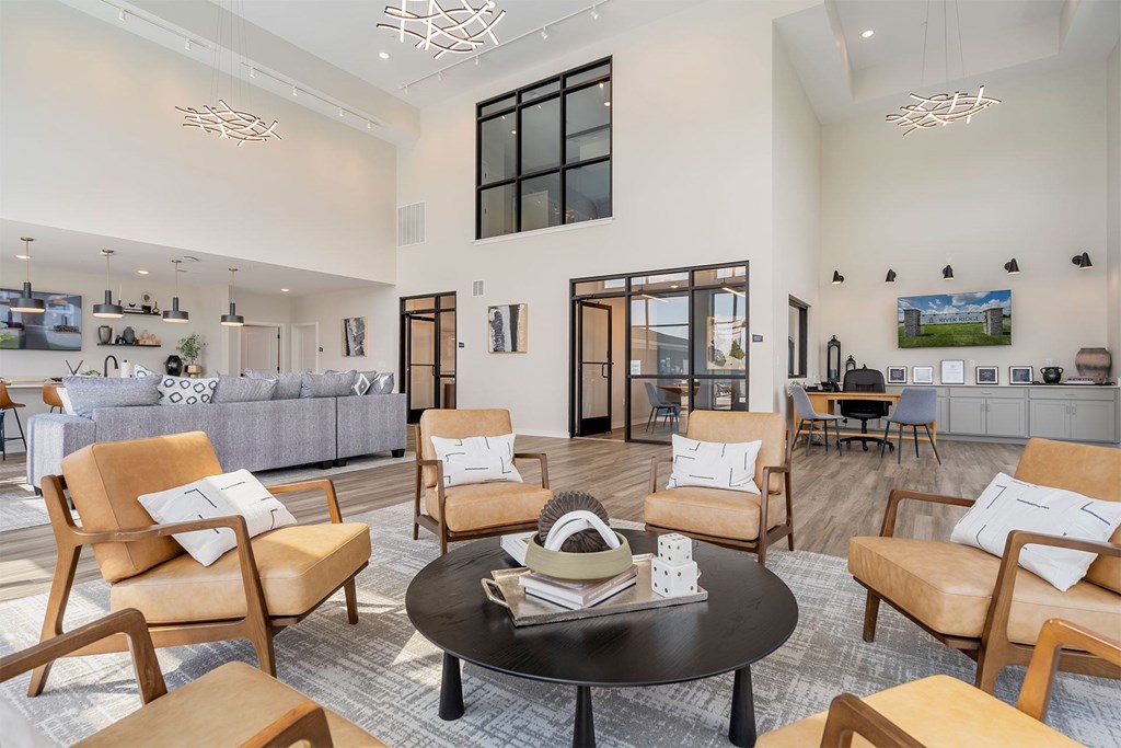 A living room with a grey couch, a coffee table, and a large window.