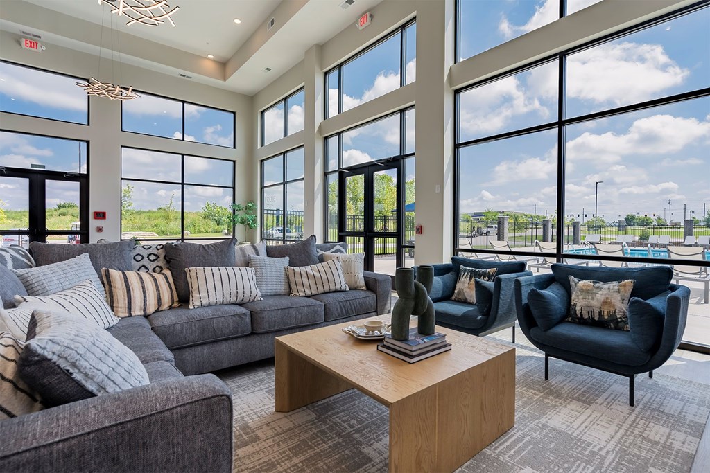 A living room with a grey couch, a black armchair, and a wooden coffee table.