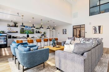 A living room with a grey couch and blue chairs.