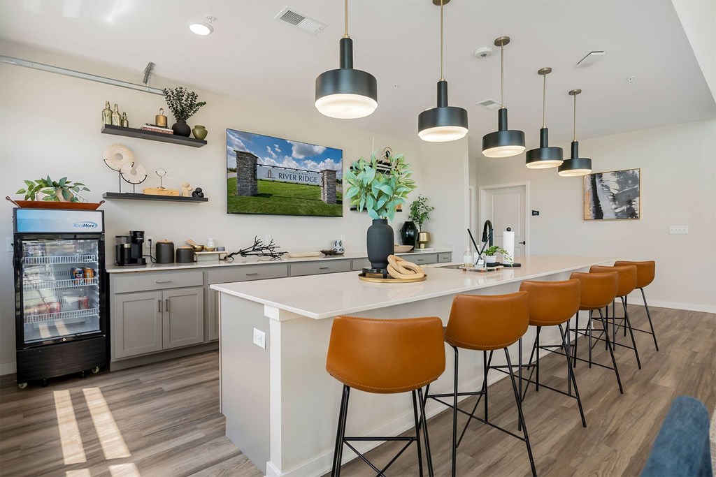 A kitchen with a white island and brown chairs.