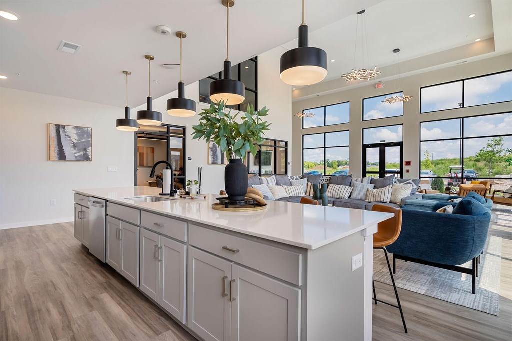 A modern kitchen with a large island and pendant lights.