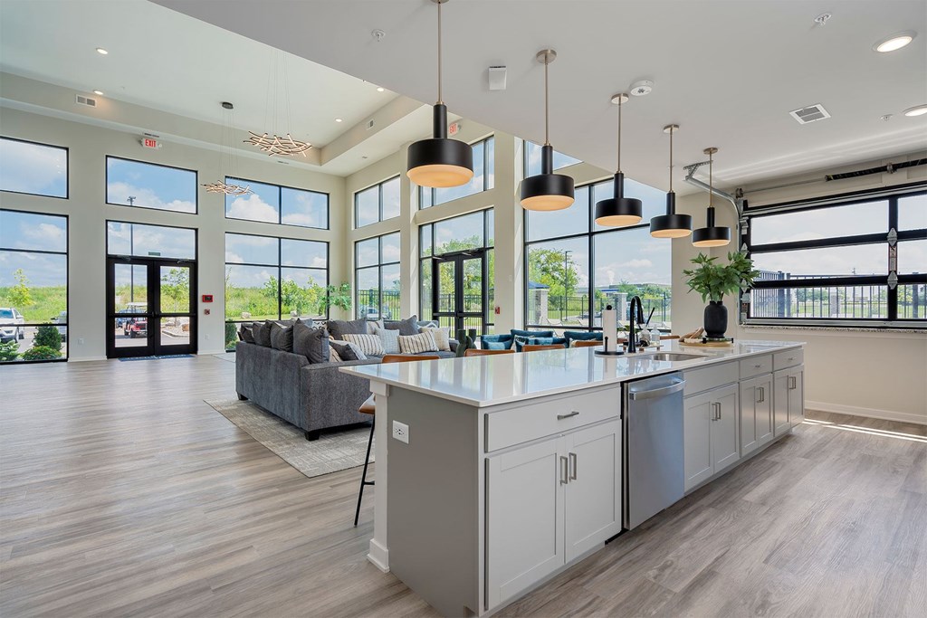 A modern kitchen with a large island and pendant lights.