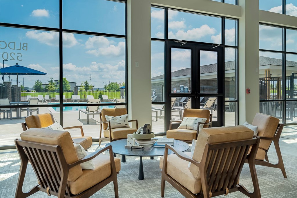 A room with a table and chairs in front of a glass wall.