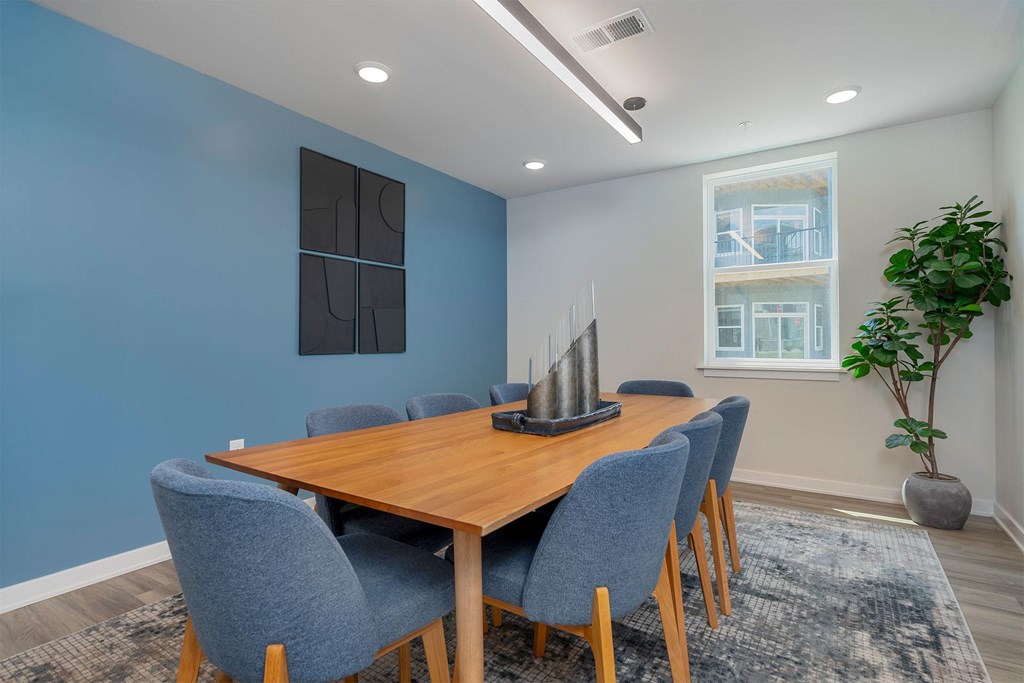 A dining room with a wooden table and blue chairs.