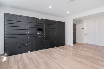 A large, black, LUXE branded wardrobe in a room with wooden flooring.