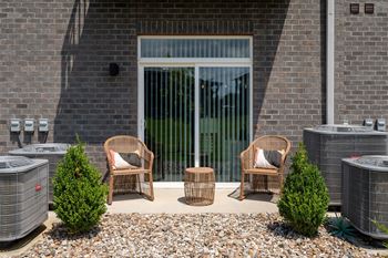 Four wicker chairs are placed in front of a glass door.