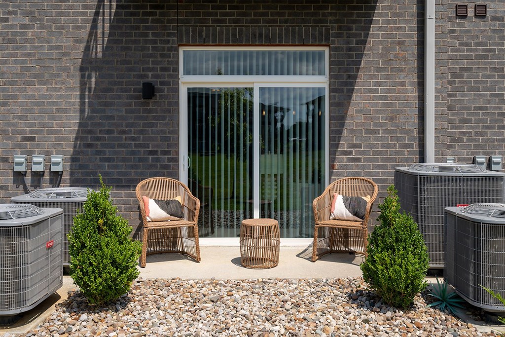 Four wicker chairs are placed in front of a glass door.